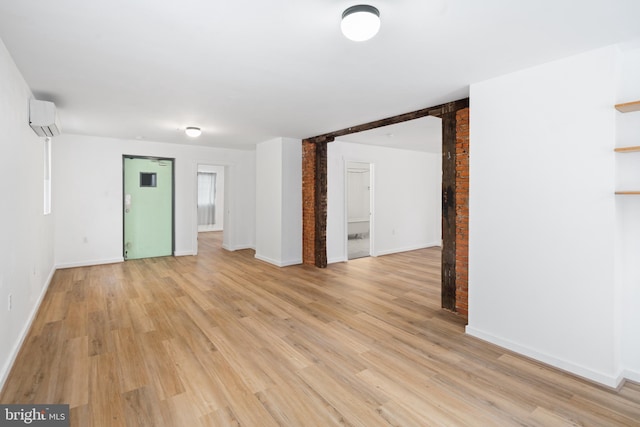 empty room with light hardwood / wood-style flooring and a wall unit AC