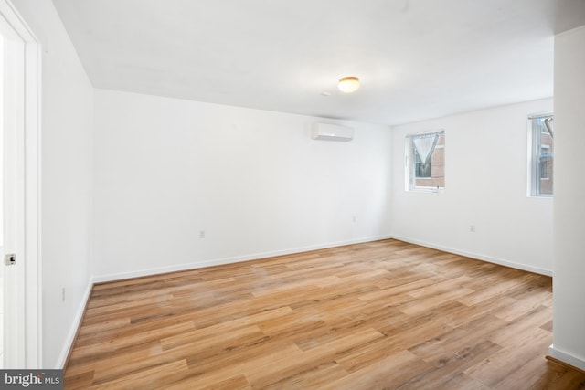 empty room with light hardwood / wood-style floors and a wall mounted AC