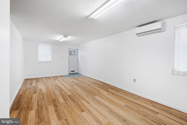 empty room featuring light hardwood / wood-style floors and a wall mounted AC