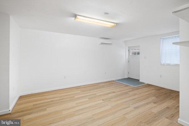 empty room featuring light wood-type flooring and a wall mounted AC