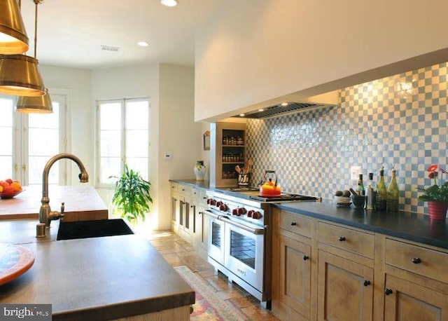 kitchen with decorative backsplash, double oven range, sink, and hanging light fixtures