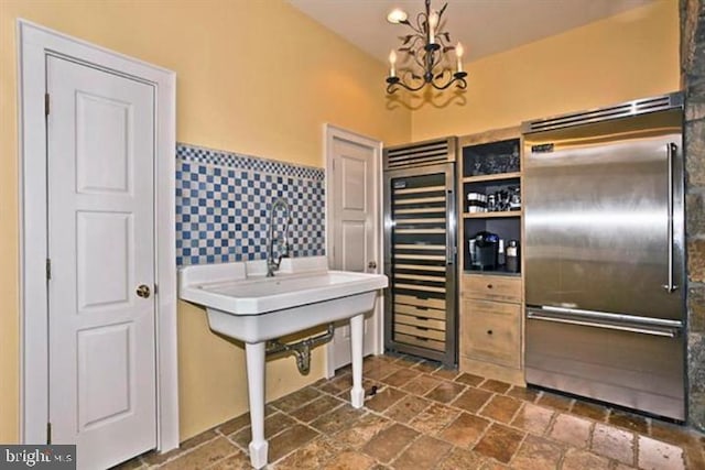 kitchen with wine cooler, pendant lighting, a chandelier, and stainless steel built in refrigerator