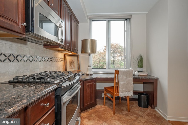 kitchen featuring backsplash, stainless steel appliances, plenty of natural light, and dark stone counters