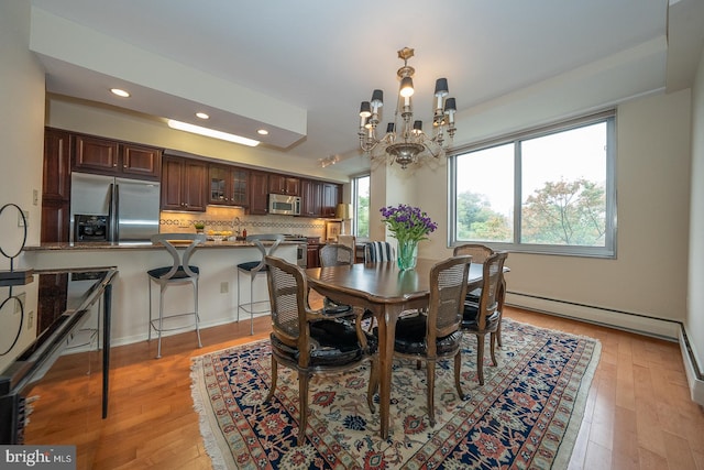 dining space featuring an inviting chandelier and light wood-type flooring