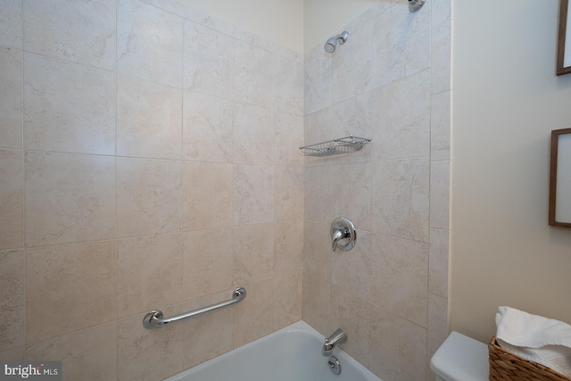 bathroom featuring tiled shower / bath and toilet