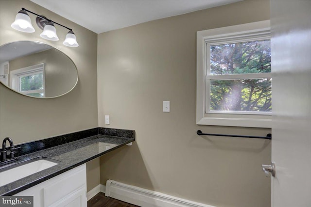 bathroom featuring baseboard heating, plenty of natural light, vanity, and hardwood / wood-style flooring