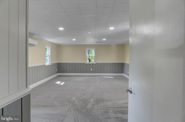 carpeted empty room featuring a wall unit AC