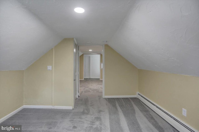 bonus room with baseboard heating, a textured ceiling, light colored carpet, and vaulted ceiling