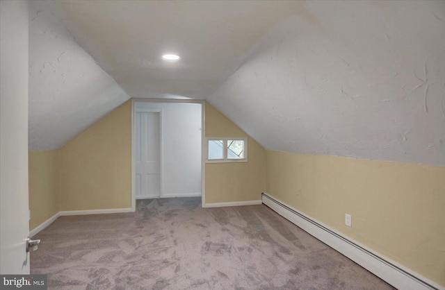 bonus room featuring a textured ceiling, light colored carpet, lofted ceiling, and baseboard heating