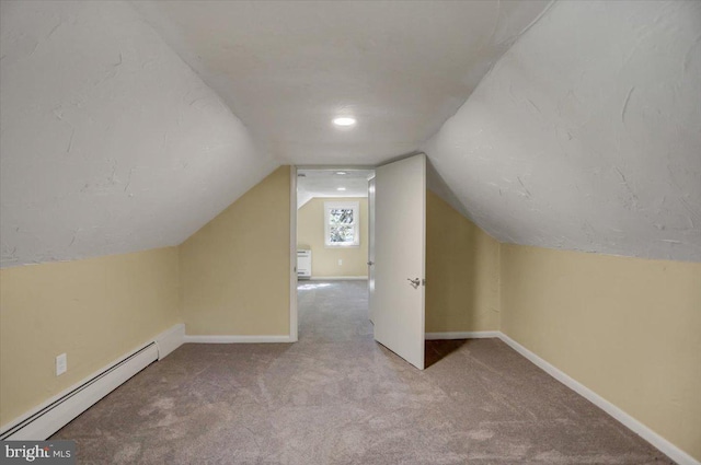 additional living space with carpet flooring, a baseboard radiator, and vaulted ceiling