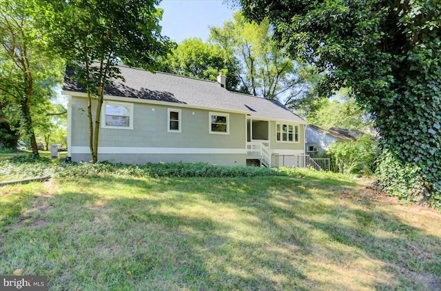 rear view of property featuring a lawn