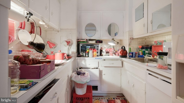 kitchen featuring tasteful backsplash, sink, and white cabinets