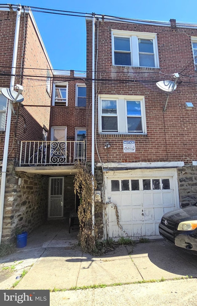 back of house with a balcony and a garage