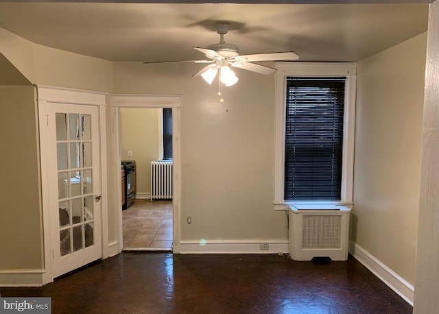 unfurnished room featuring ceiling fan, dark wood-type flooring, and radiator