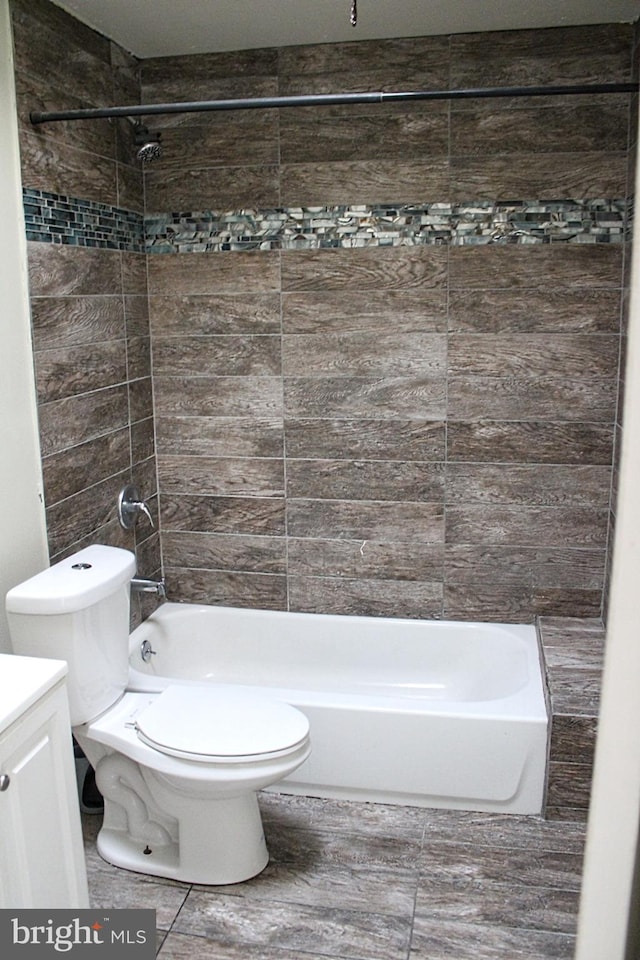 full bathroom featuring vanity, toilet, and tiled shower / bath