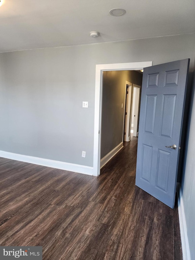 unfurnished room with dark wood-type flooring