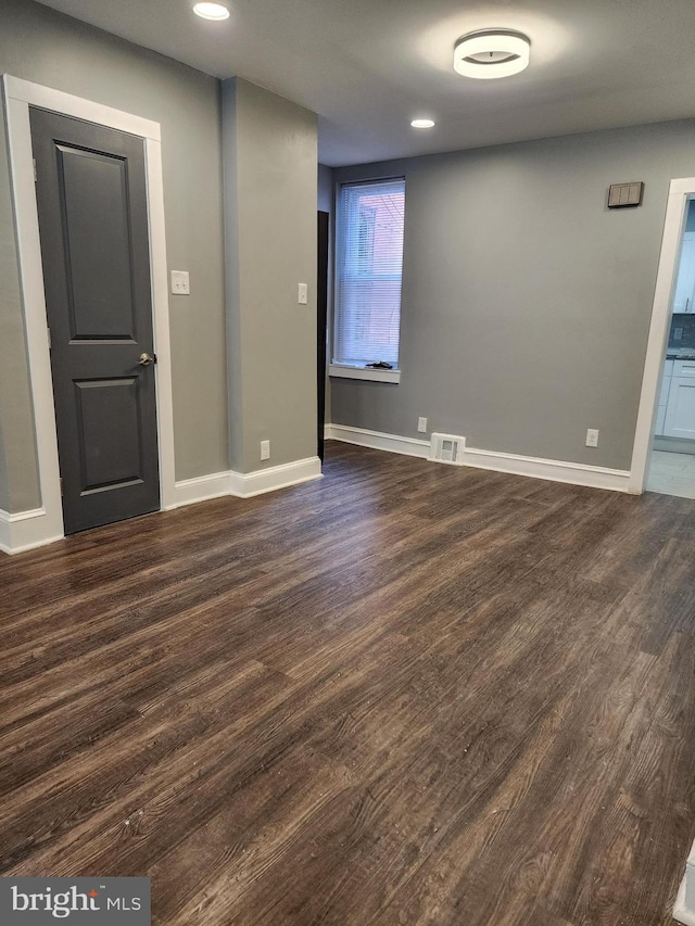 empty room with dark hardwood / wood-style flooring