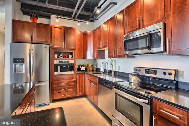 kitchen featuring dark stone countertops, sink, and stainless steel appliances