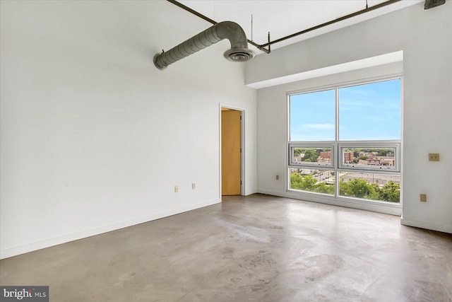 spare room with concrete floors and a high ceiling