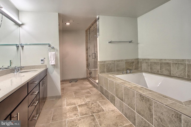 bathroom featuring vanity and independent shower and bath