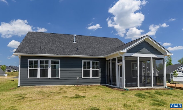 back of property with a lawn and a sunroom