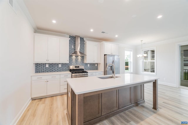 kitchen featuring white cabinetry, a kitchen island with sink, stainless steel appliances, and wall chimney range hood