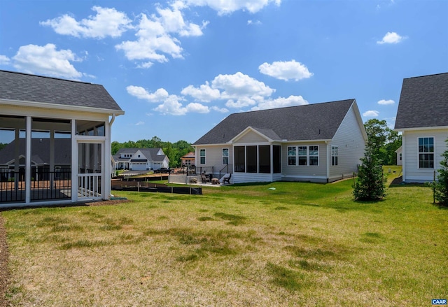 back of house with a sunroom and a yard