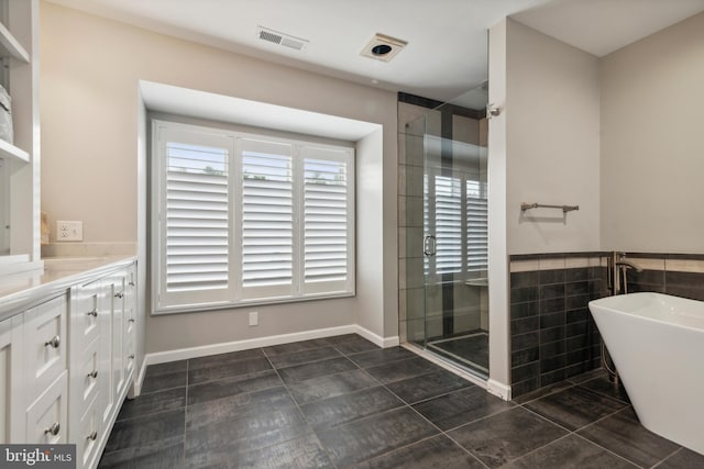 bathroom featuring tile patterned floors, separate shower and tub, vanity, and tile walls