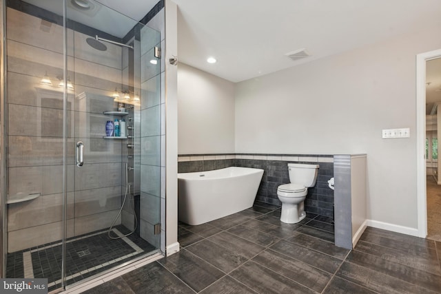 bathroom with toilet, tile walls, and independent shower and bath