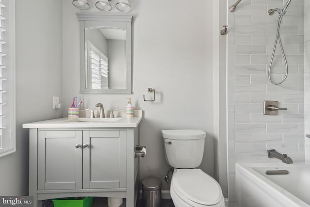 full bathroom featuring vanity, tiled shower / bath combo, and toilet