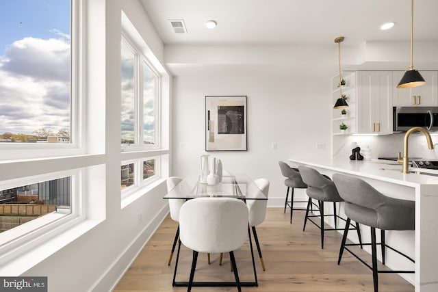 dining area with light hardwood / wood-style flooring and sink