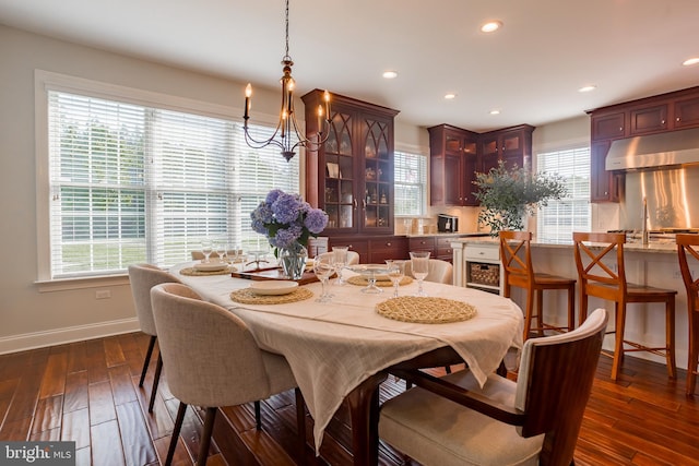 dining space with dark wood-type flooring and a notable chandelier