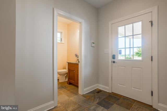 doorway to outside with dark tile patterned floors