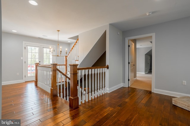 hall featuring hardwood / wood-style flooring and a chandelier