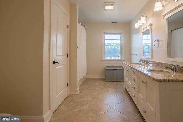 bathroom with tile patterned flooring and dual bowl vanity