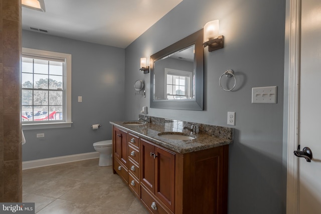 bathroom with tile patterned flooring, dual bowl vanity, and toilet