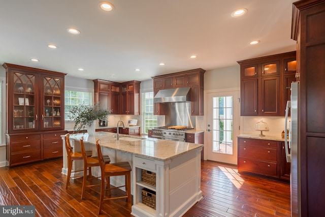 kitchen with wall chimney range hood, sink, plenty of natural light, and backsplash