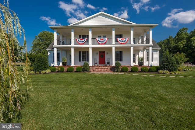 neoclassical home featuring covered porch, a balcony, and a front lawn