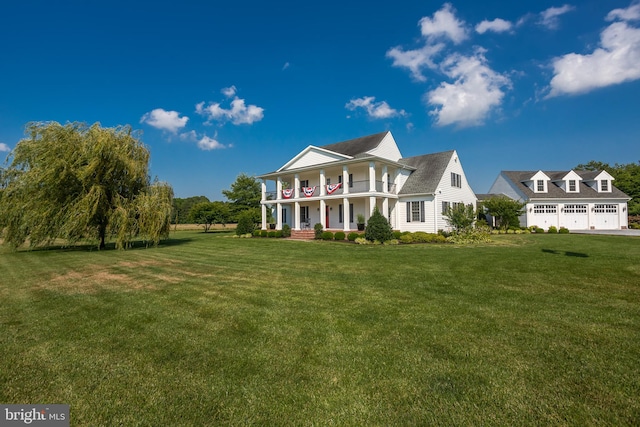 view of front facade featuring a garage, a front lawn, and covered porch