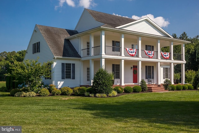 view of front of home with a balcony, a porch, and a front yard