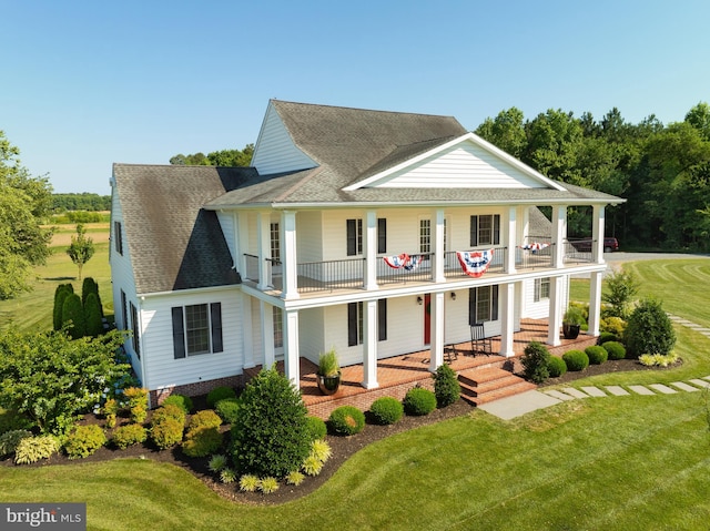 view of front of property with a porch, a balcony, and a front yard