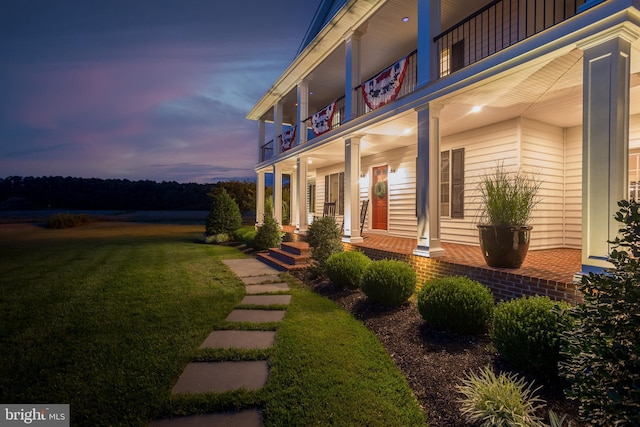 exterior space featuring a porch and a lawn