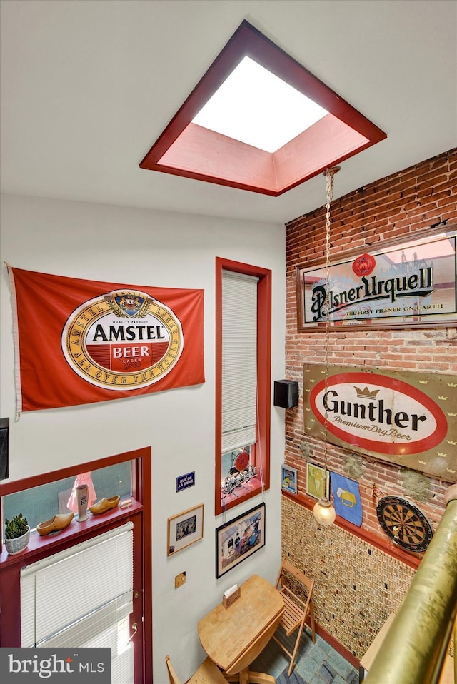 interior space with brick wall and a skylight