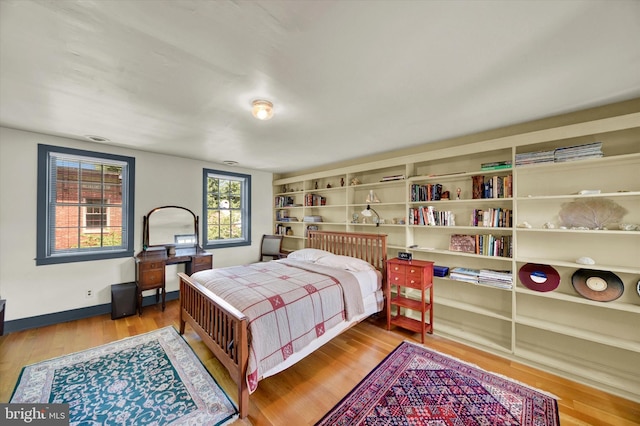 bedroom with baseboards and wood finished floors