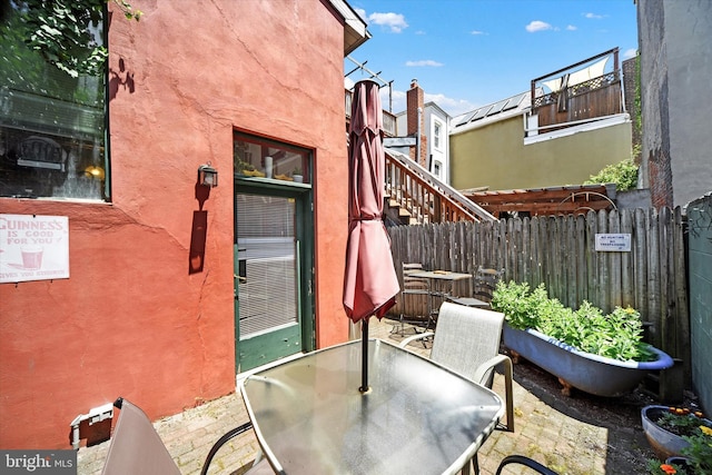 view of patio featuring outdoor dining area and fence