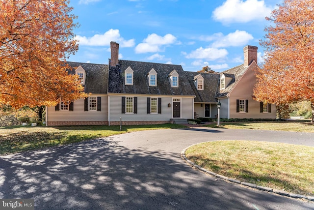 cape cod-style house featuring a front lawn