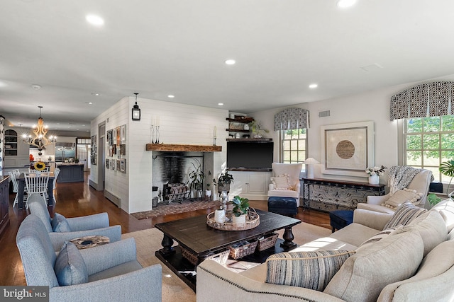 living room featuring wood-type flooring and an inviting chandelier