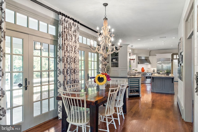 dining area featuring a notable chandelier, dark wood-type flooring, wine cooler, and french doors