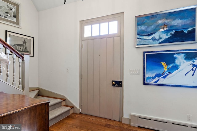 foyer with baseboard heating and hardwood / wood-style flooring