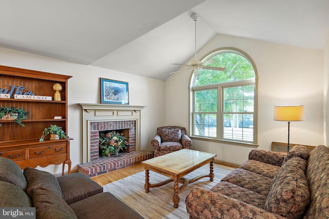 living room featuring a fireplace, a healthy amount of sunlight, lofted ceiling, and light hardwood / wood-style floors